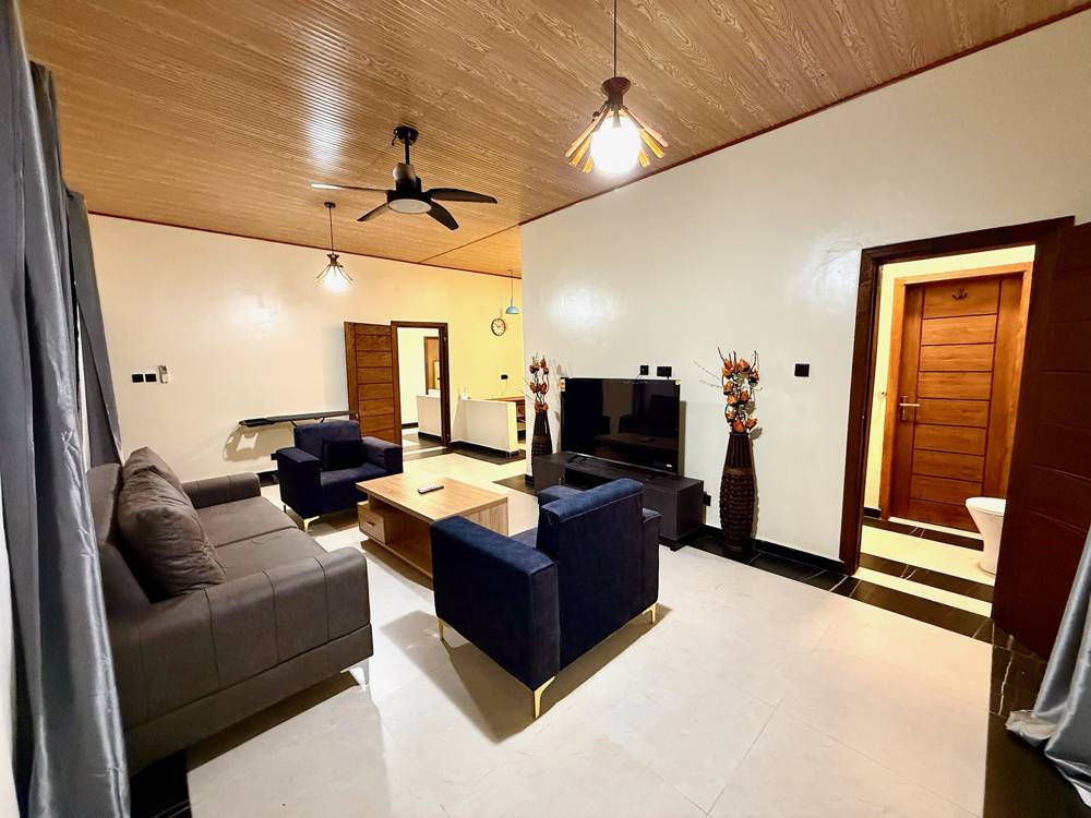 Bright luxury suite living room with sofa, armchairs and wooden ceiling