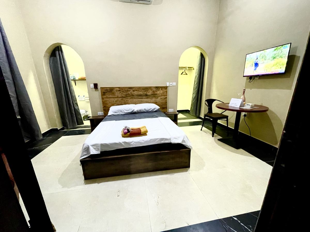 Economy studio suite, Studio suite with bed, arched alcoves, wall-mounted TV and table