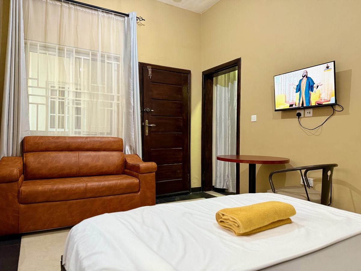 Queen studio suite with sofa, bed and TV
