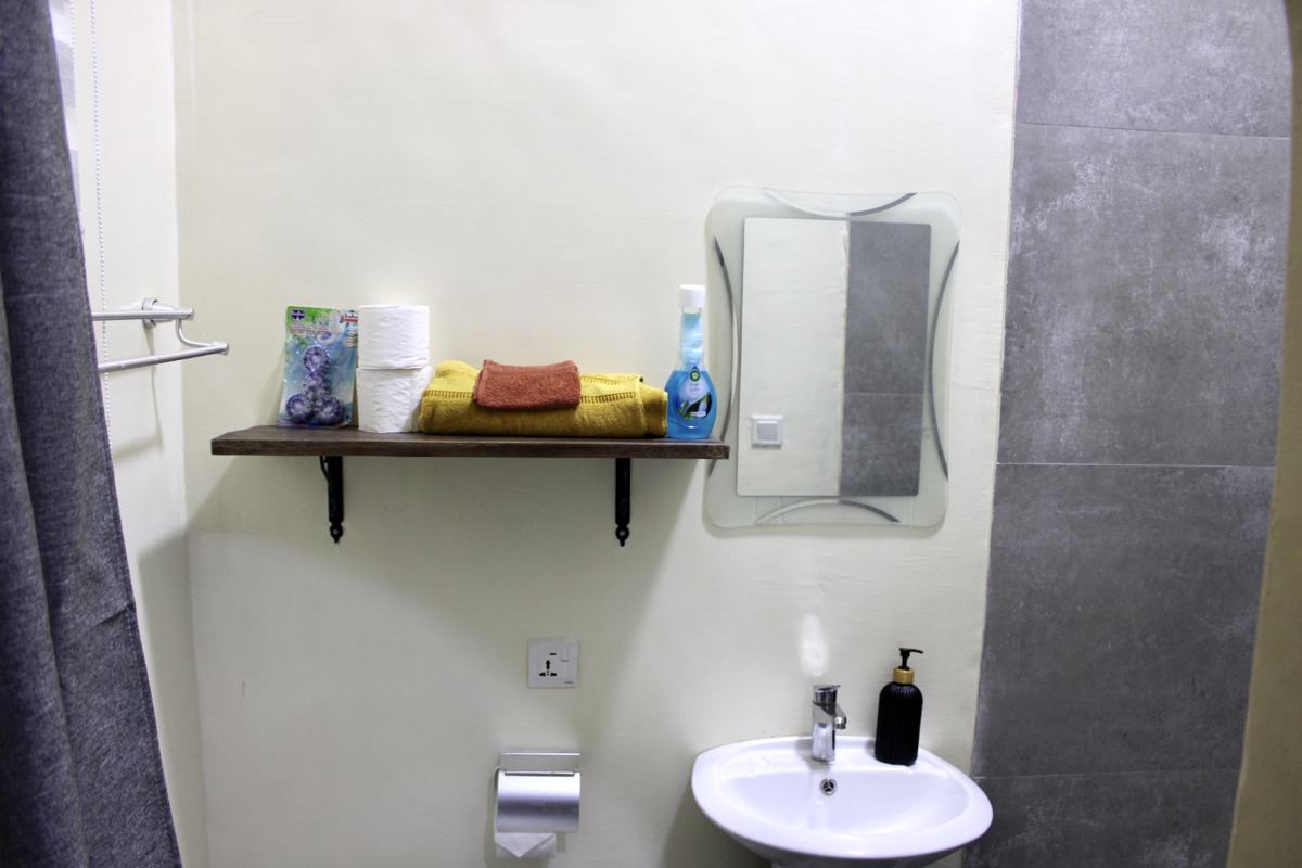 Queen studio suite bathroom shelf with towels, mirror and sink